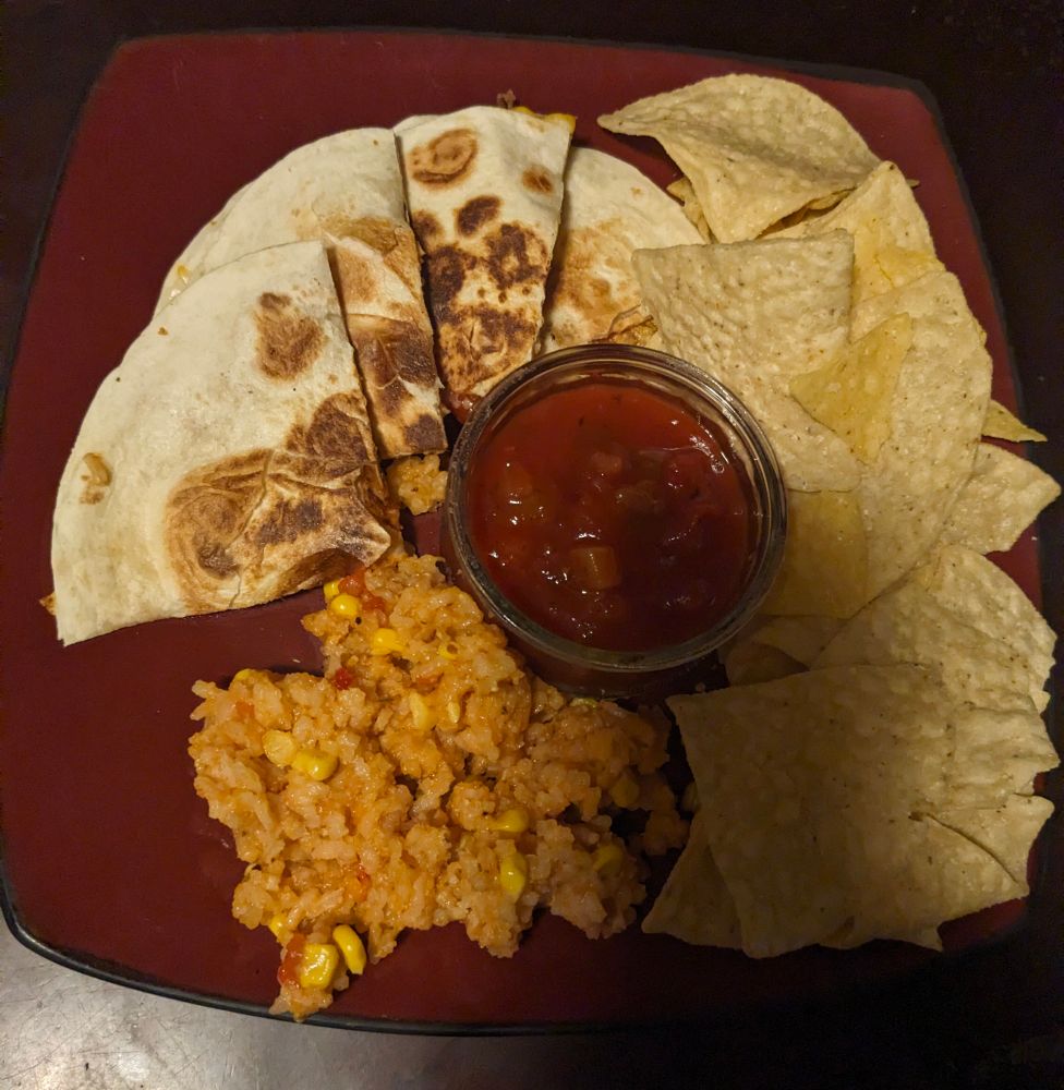 Food plate with a quesadilla,  Spanish rice, chips & salsa
