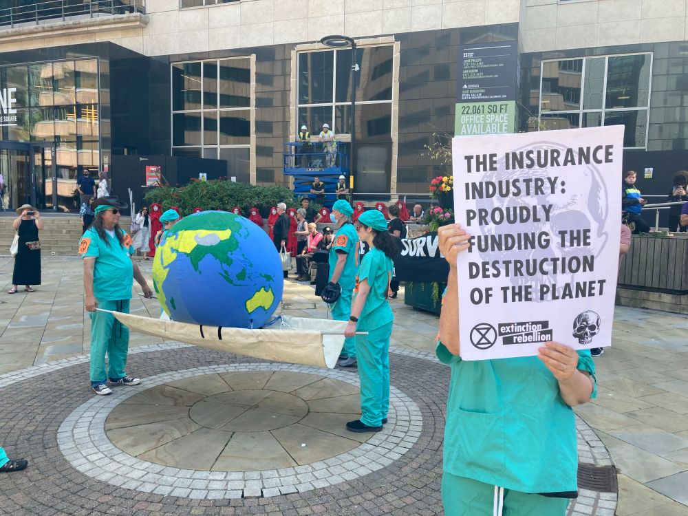 Planet Medics: A group dressed in medical scrubs carry a model of the earth on a stretcher