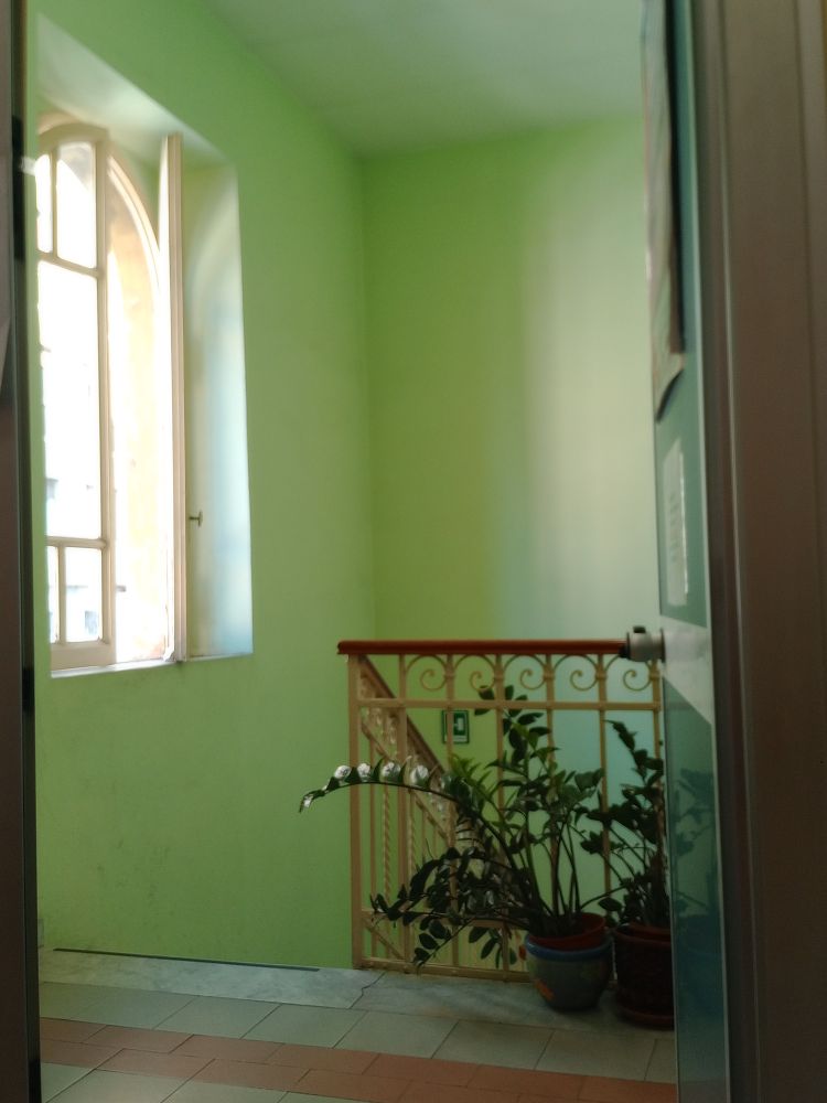 The photo shows the interior of an old house in Rome, with walls painted in mint green