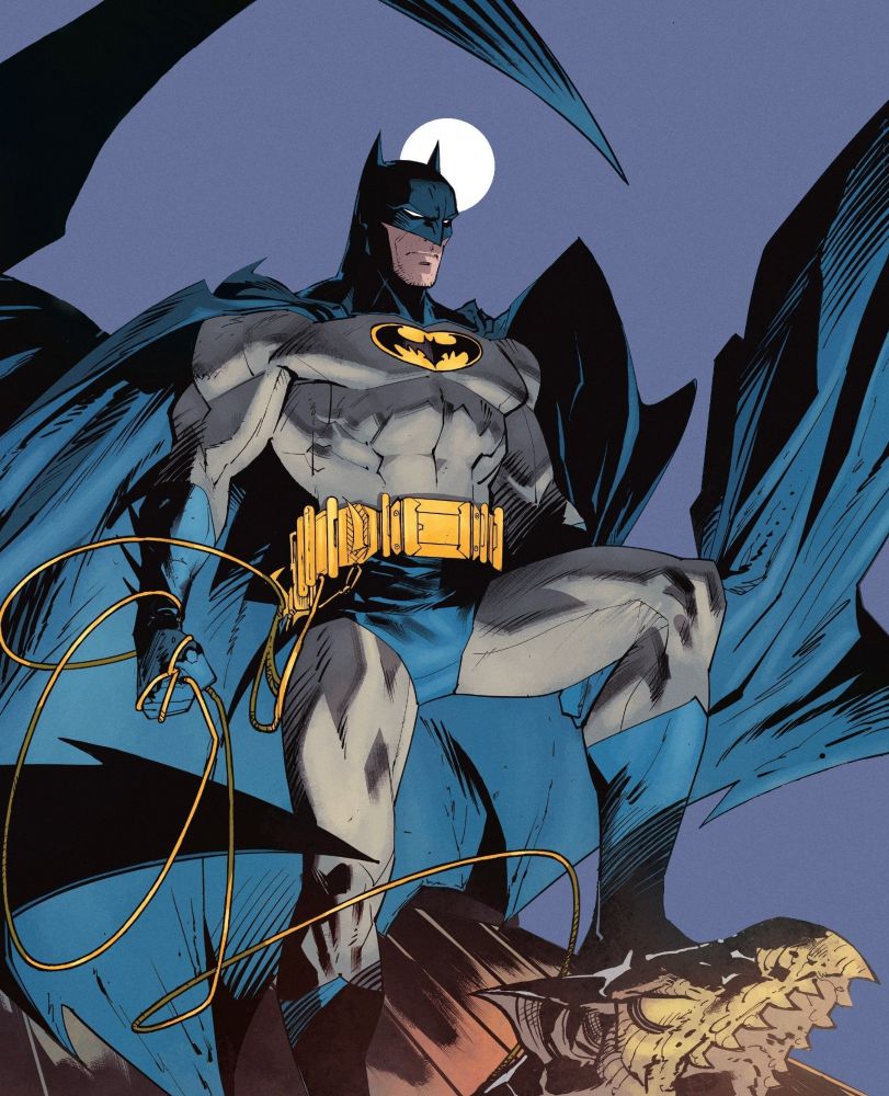 Batman standing on a stone gargoyle on top of a building. His cape, cowl, boots, and trunks are blue, with the rest being grey, except for the utility belt and the oval in which the bat symbol rests. 