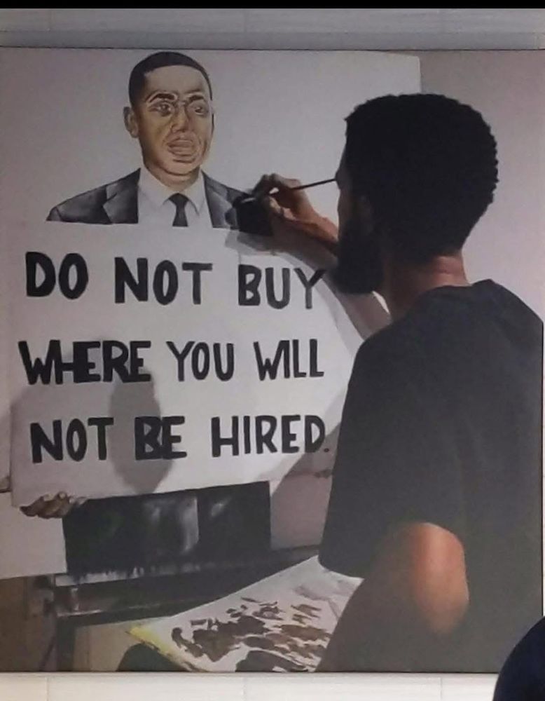 Man painting a man holding a sign that reads “do not buy where you will not be hired”