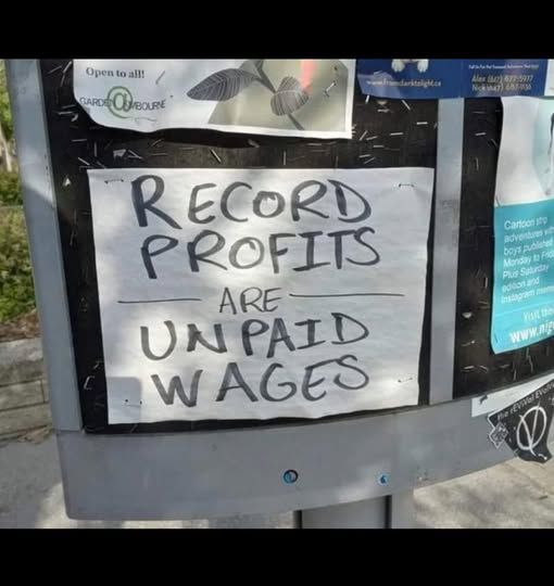 sign reads:

record profits are unpaid wages