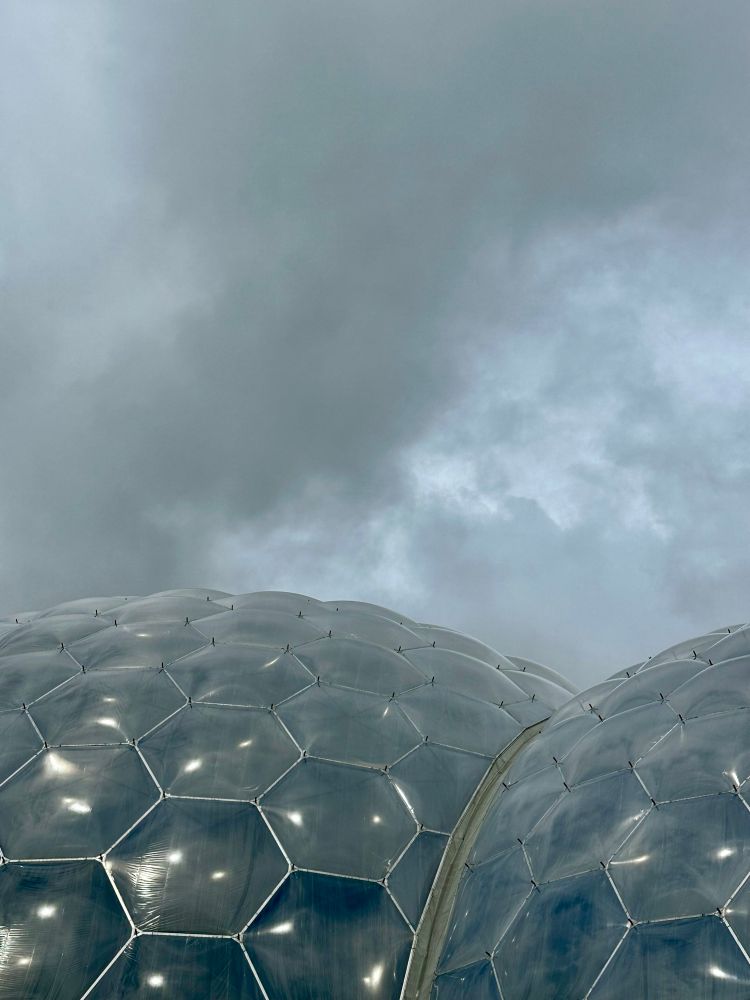 Eden Project domes with hexagonal plastic panes, under a rainy sky. Kind of gloomy. 