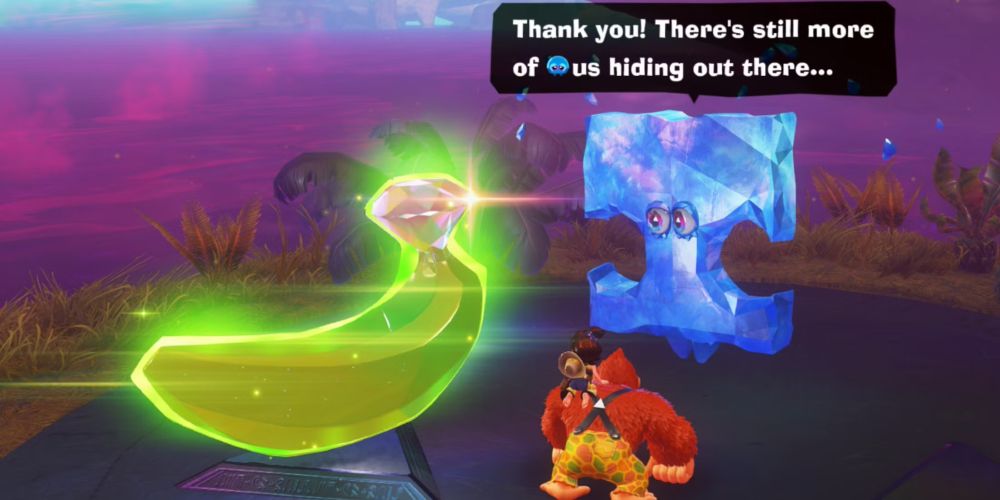 A vibrant 3D-rendered jungle scene from a video game features Donkey Kong swinging from a vine in the top left corner while other characters navigate the lush, green environment below. The jungle is filled with large leaves, wooden platforms, and tropical plants. Bright yellow bananas float in midair, acting as collectible items, and two large banana-shaped fragments are highlighted in the scene. One rests on a platform near the center, and another is partially hidden in the foliage. 