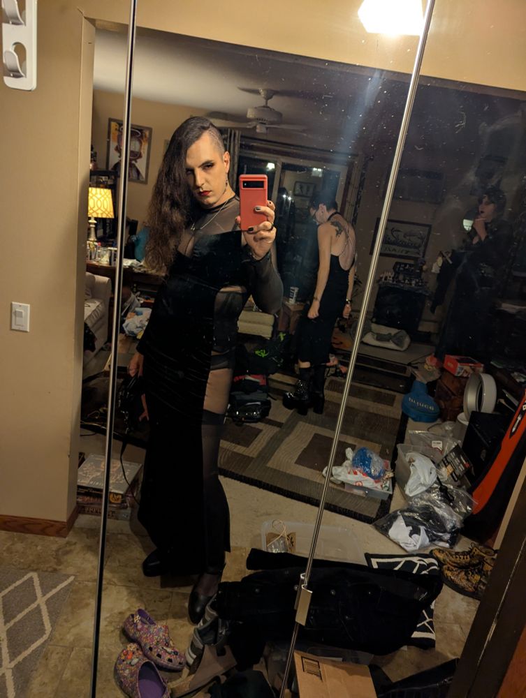 Genderfluid woman in a revealing velvet and mesh dress