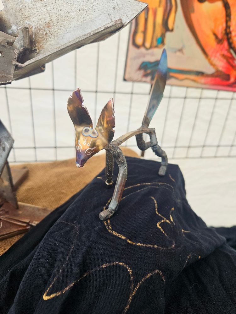 A scrap metal sculpture of an ambiguous but foxy canine with a saucy expression 