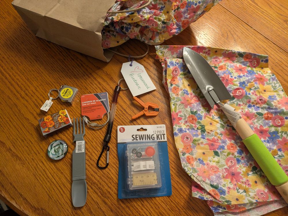 Goodies from the hardware store gift bag, including a sewing kit, skinny spade, cute matches, and keychains and other little various bits (like a tiny measuring tape and a tiny clamp)