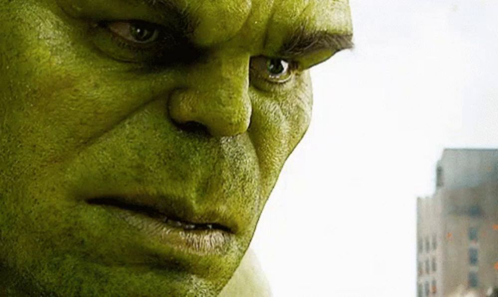 a close up of hulk 's face with a building in the background