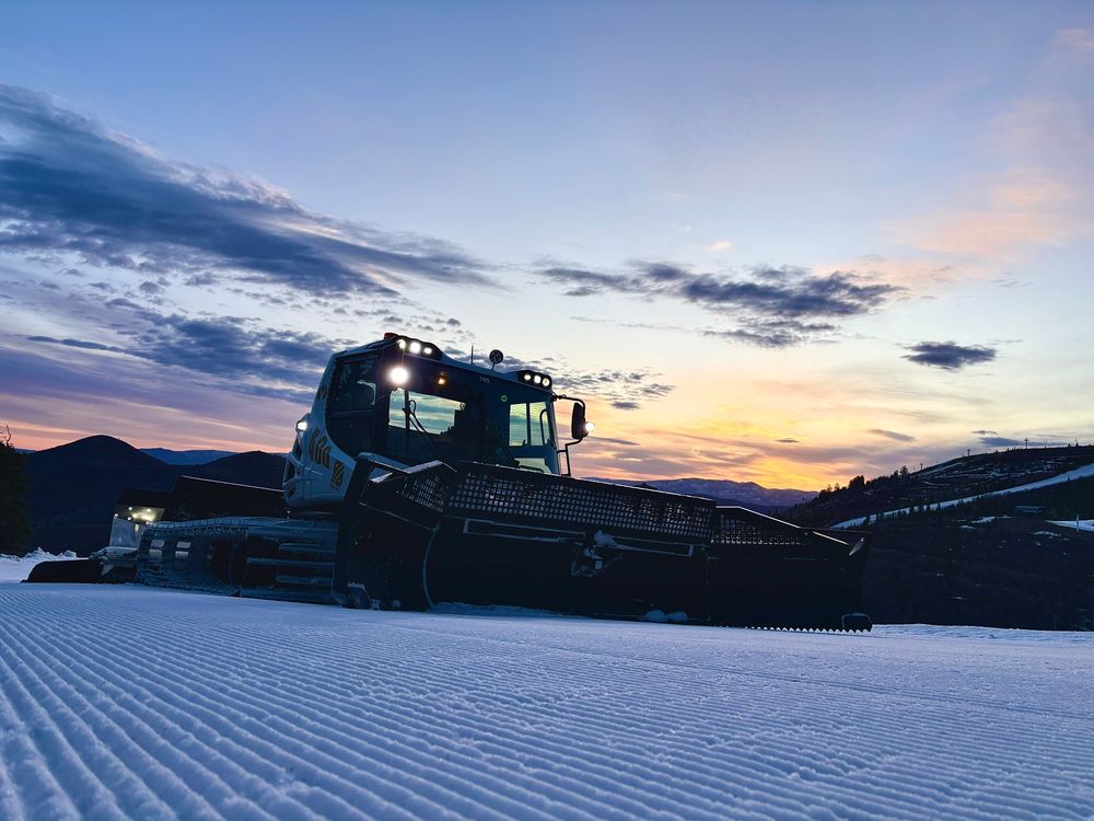 Pistenbully PB400 Park Pro snow-groomer silhouetted against a Utah sunrise 