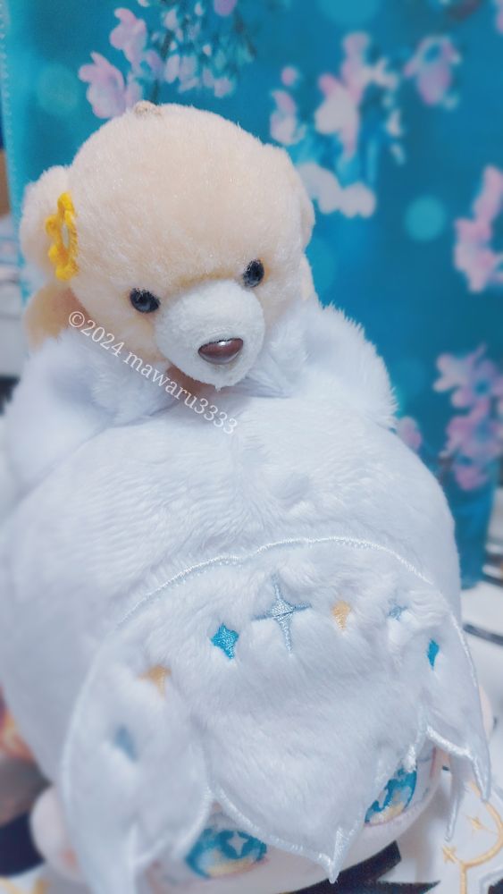 白いオコジョのケモミミぬいぐるみの頭に乗るクマのぬいぐるみ