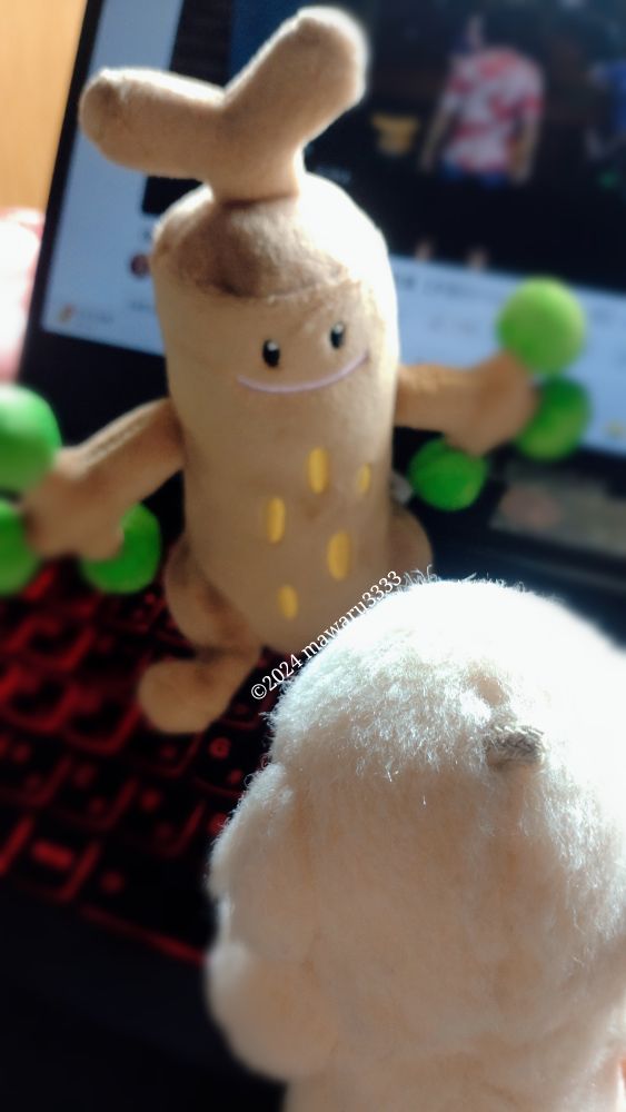 ウソッキーのぬいぐるみがクマのぬいぐるみを見ている。クマはカメラを背にしている