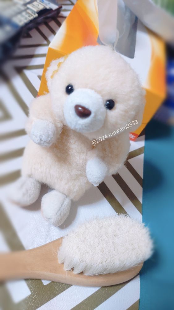 ぬいぐるみ用のブラシを目の前に置かれるクマのぬいぐるみ