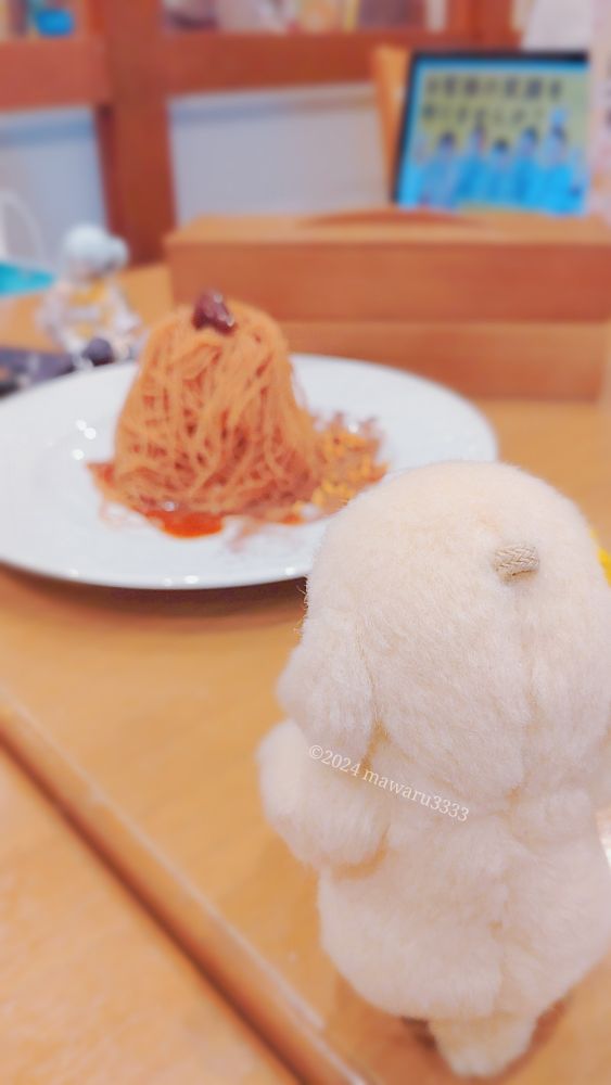 モンブランを遠くから眺めるクマのぬいぐるみ（カメラからは後ろ向き）