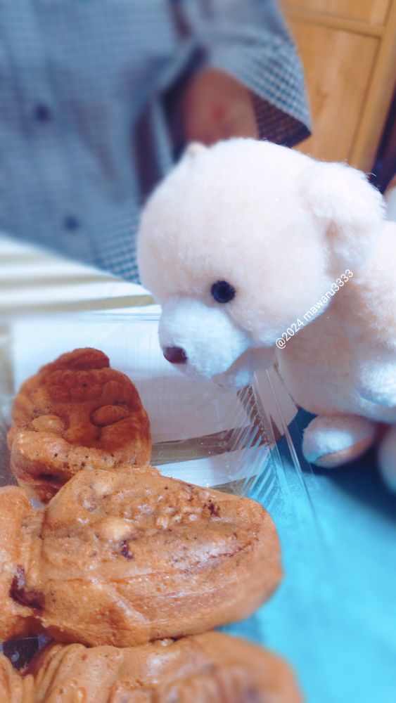 ツボのおまんじゅうを近くで見るクマのぬいぐるみ（横顔）
