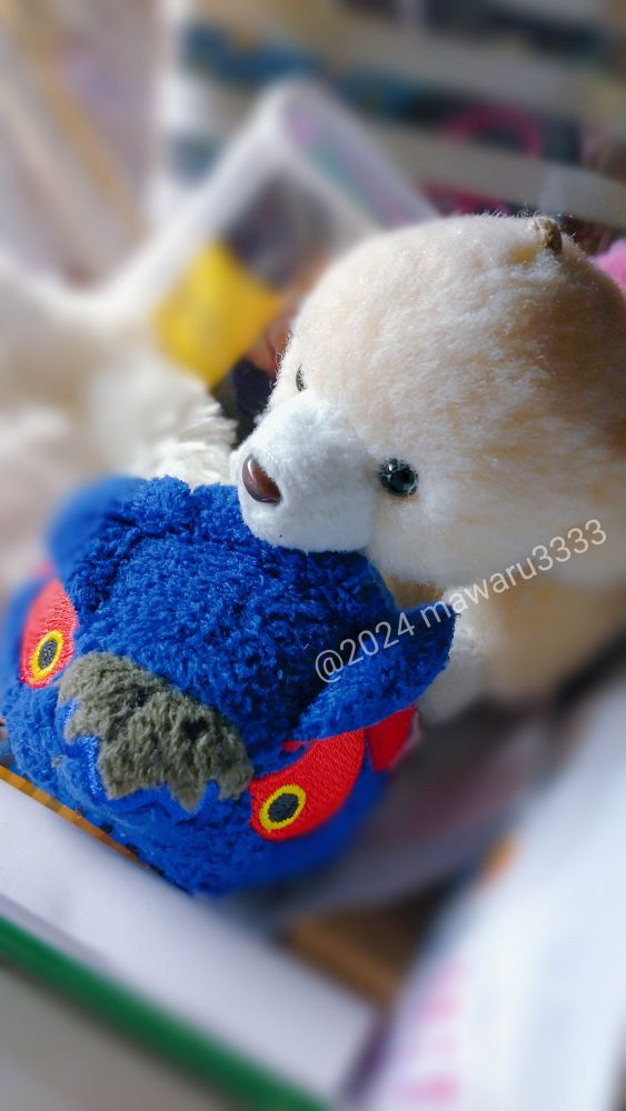 カプころん（ナルガクルガのデフォルメミニぬいぐるみ）に鼻を乗っけるクマのぬいぐるみ