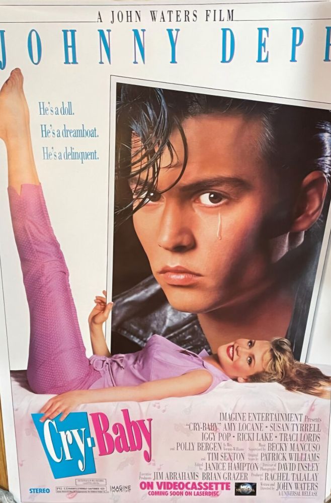 He's a doll, he's a dreamboat, he a delinquent. A John Waters movie starring Johnny Depp. Girl smiling at a picture of a guy.