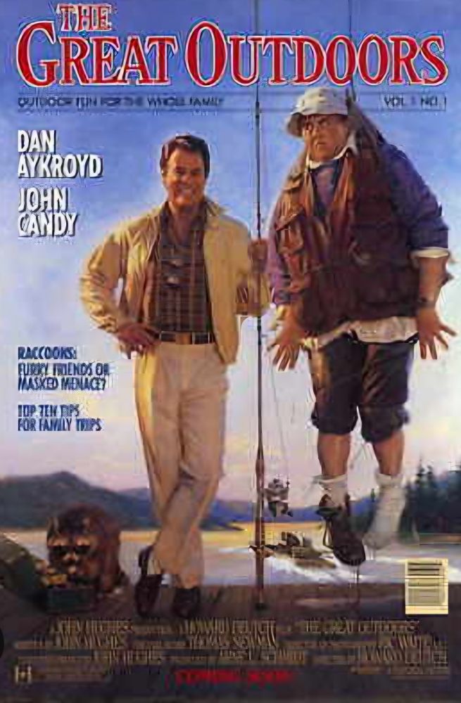 Starring Dan Aykroyd and John Candy. A man smiling, holding a fishing rod that has hooked someone hanging in the air.