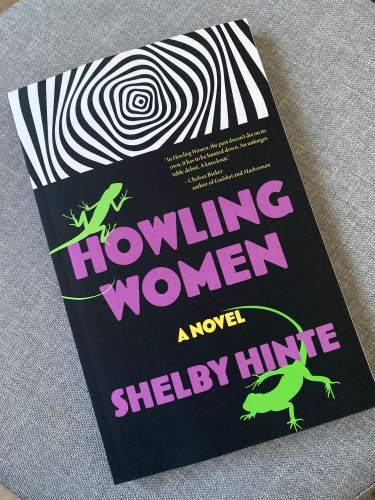 Cover of howling women by Shelby Hinte (purple type on black with green iguanas and a hypnotic black and white graphic) 