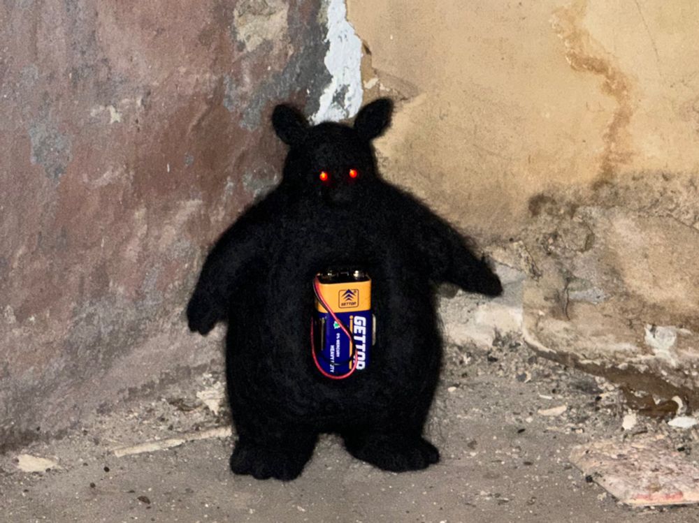 Flash photo of Fire Hazard standing in a dirty concrete corner.