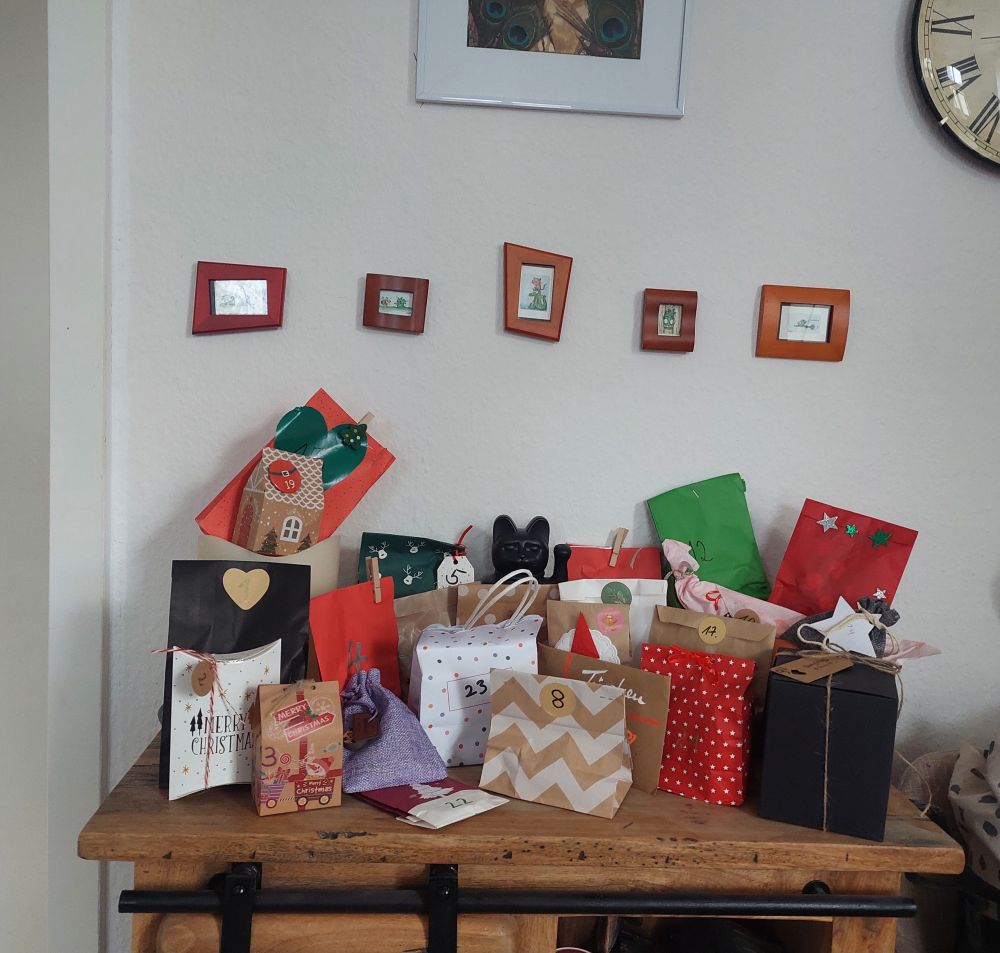 Adventskalender Päckchen und Tütchen aufgestellt auf einem highboard 