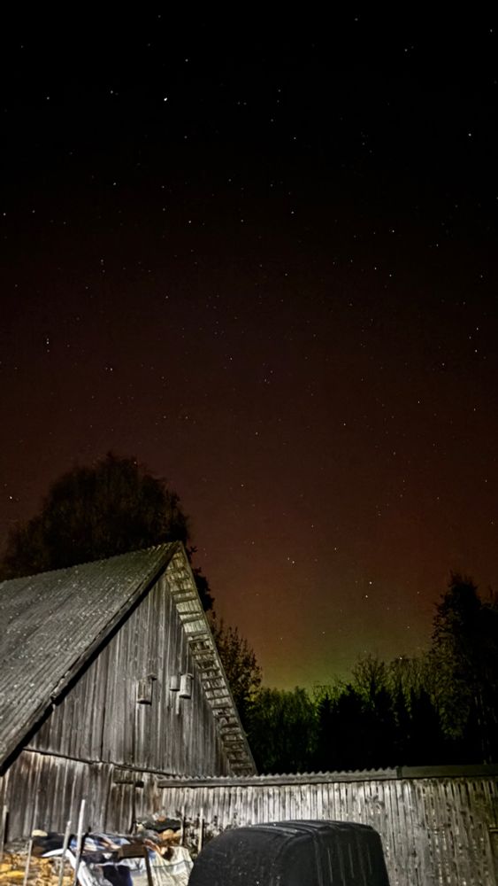 esiplaanil küün ja puukuur, tagaplaanil virmalistega taevas