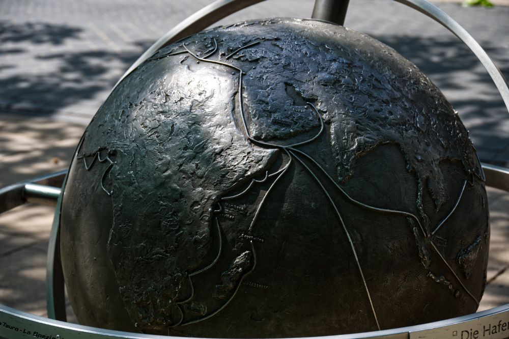 Eine Weltkugel aus Metall, auf der Afrika mit einigen Ortsbezeichnungen zu sehen ist. Die Metallkugel reflektiert dabei leicht das Sonnenlicht.