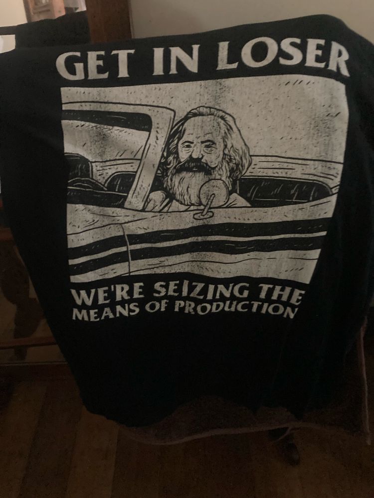 A black tshirt emblazoned with an image of Karl Marx in an American convertible. He is saying to the viewer/reader: “Get in loser, we’re seizing the means of production”
This is a reference to a popular film the title of which escapes me, but the movie script had a young affluent white woman saying “get in loser, we’re going shopping”.
So, you know - satire and/or sarcasm.