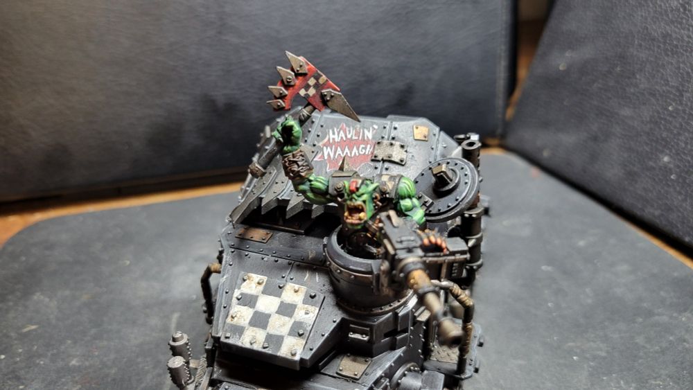 An ork inspired semi-truck kitted out with designs and graffiti including "Boyz here" "go on git" "Haulin' Waaagh" and "Da Ork Chop"