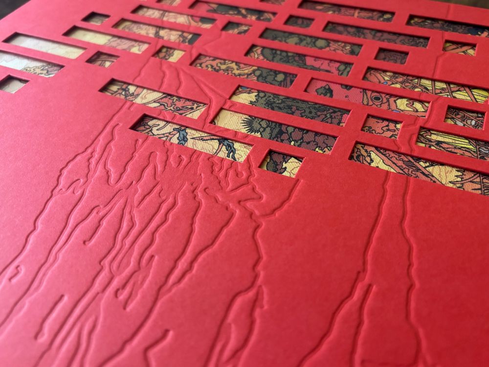 A close up photograph of the book’s sleeve, emphasizing the embossed pattern, evoking a mountainside. The cover of the book peeks through geometric shapes punched out of the sleeve