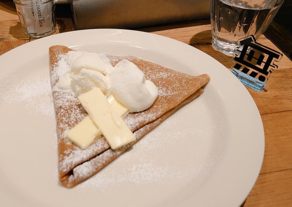 ホイップたっぷりのクレープと無のアクスタの写真