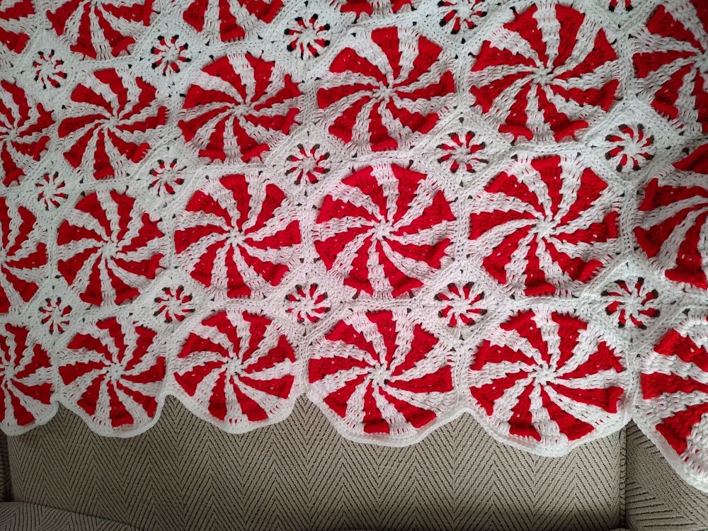 Crocheted throw in red and white that looks like peppermint candies.