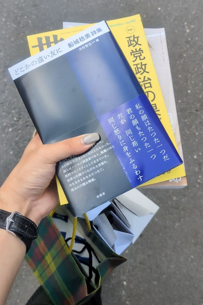 本3冊と伊勢丹のショッパーを手に歩いている