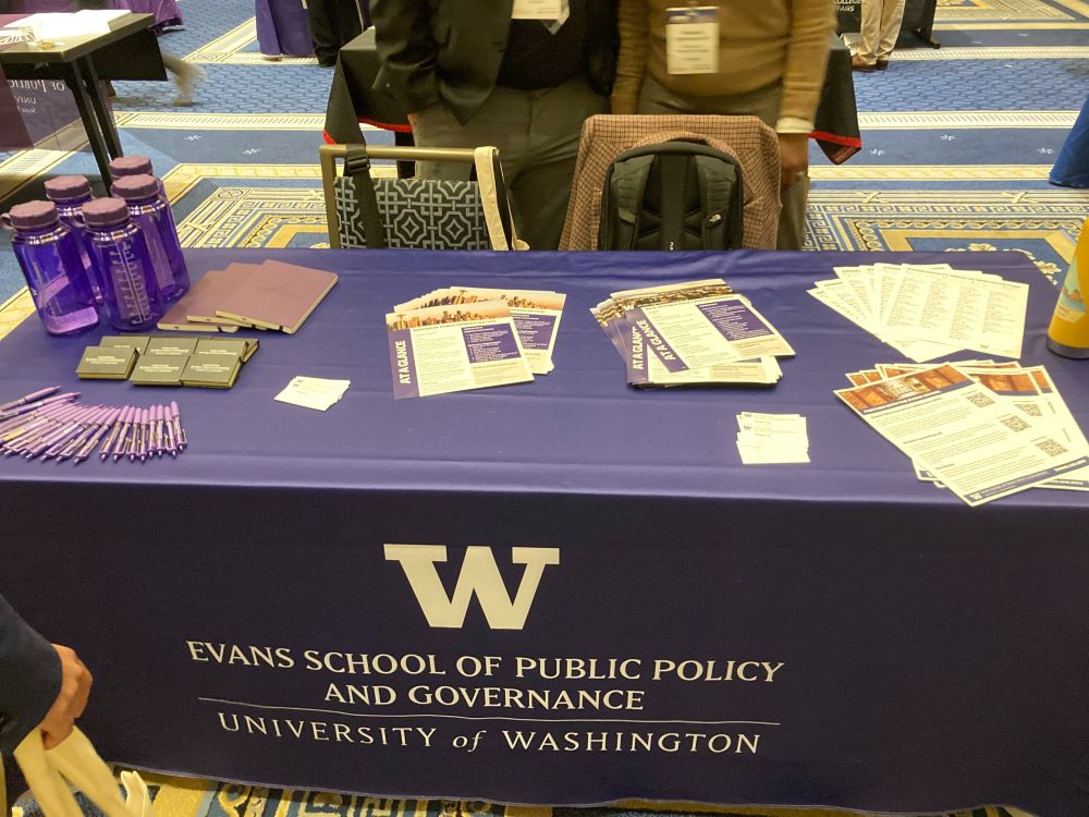 A table with an Evans School branded table cloth covered in admissions brochures