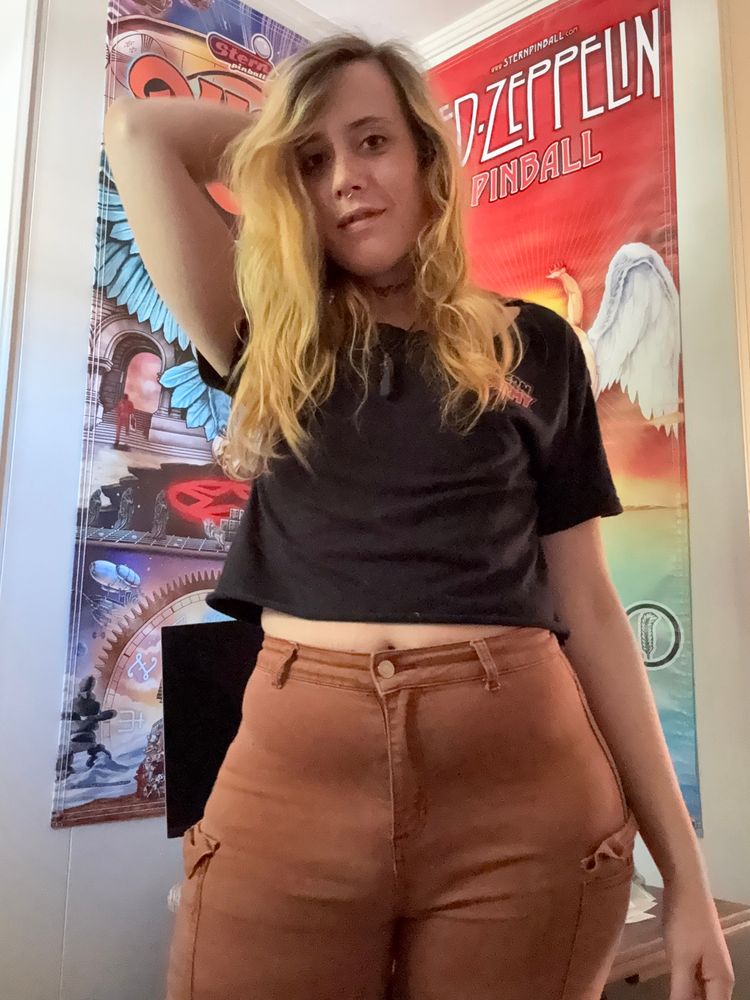 photo of a baddie in brown pants and a black cutoff stern army member shirt