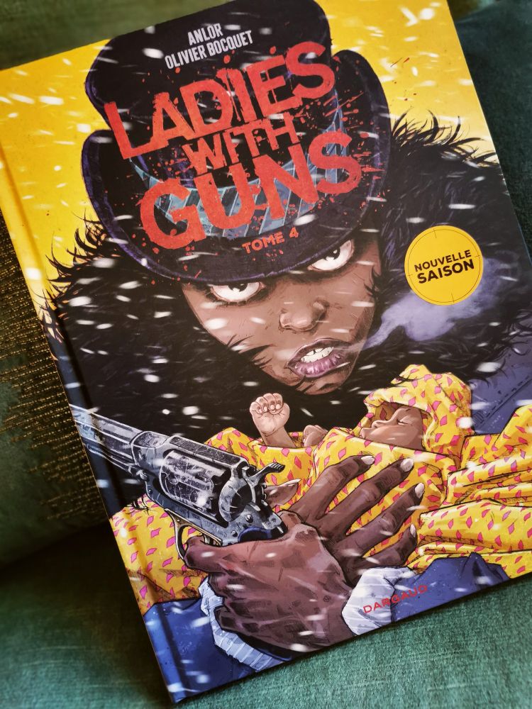 Couverture du tome 4 des Ladies With Guns : gros plan sur le visage de Cassie en serrant son bébé d'une main et tenant un pistolet de l'autre, l'air farouche et déterminée. 