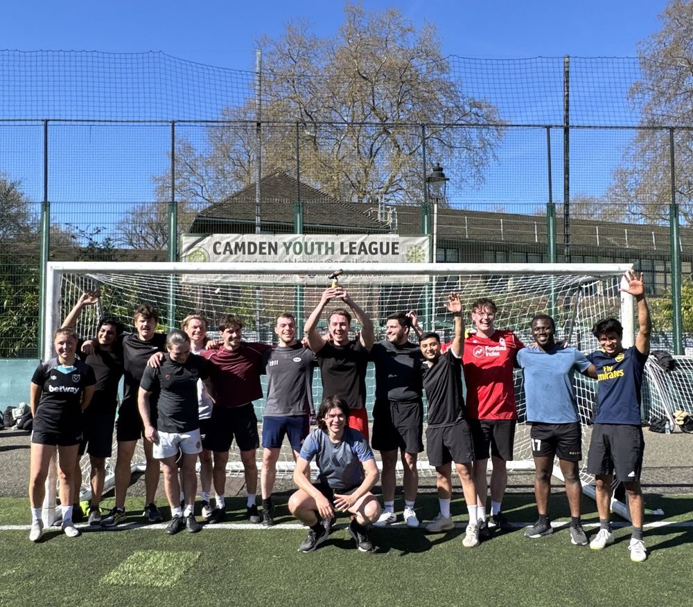 The LLM team celebrating in front of a goal on a pitch at Coram's Fields after winning the Faculty of Laws football tournament.