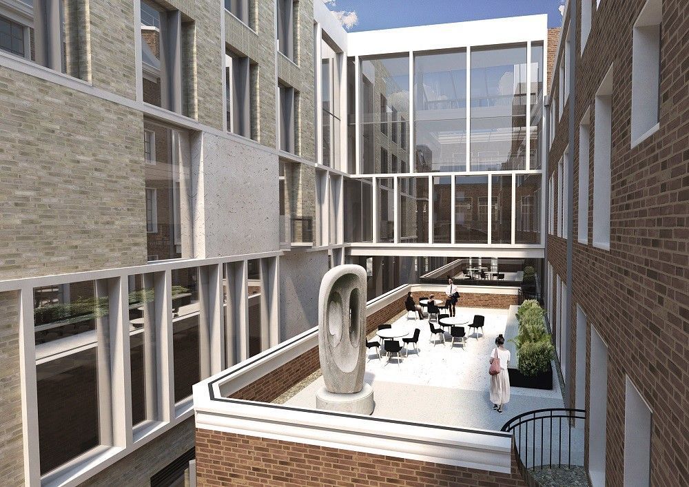 Aerial view of Bentham House courtyard at UCL Faculty of Laws, showing modern beige brick buildings connected by glass walkways, an abstract metal sculpture, outdoor tables and chairs surrounded by green plants, and a few people enjoying the terrace