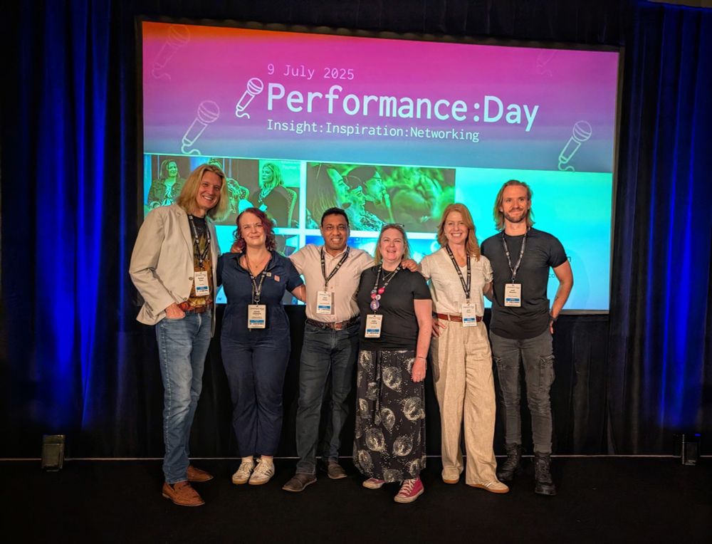 Five people stand on a stage at Develop Brighton conference in front of a screen with Performance: Day written on it 