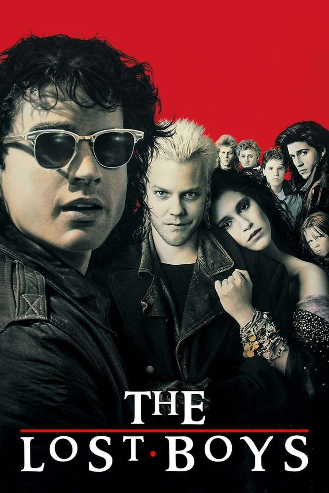 Movie poster for The Lost Boys (1987). Features 5 gorgeous 80's badboys, 1 beautiful Romani-styled woman, and 2 boys on a plain red backdrop with title below.