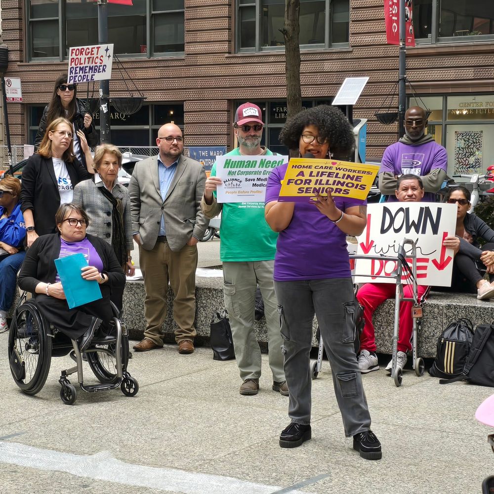 SEIU leader speaks at an outdoor rally holding a sign that says home care workers: a lifeline for Illinois seniors. Among listeners behind her is president and CEO of Access Living 