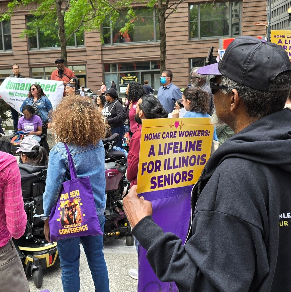 People at an outdoor rally.  One holds a sign that says Home care workers: a lifeline for Illinois seniors 