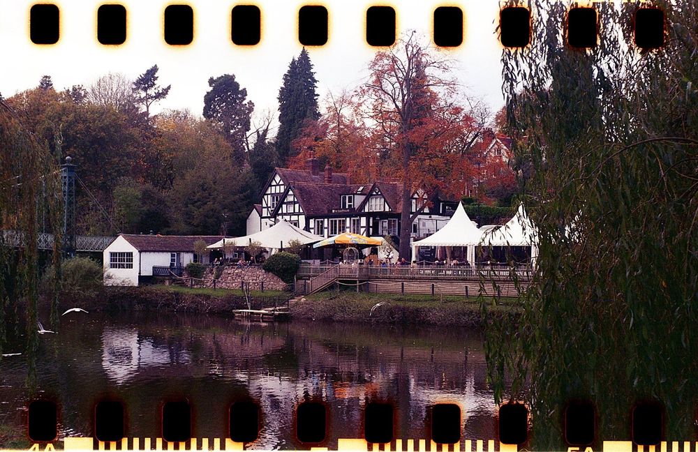 A tudor timbered restaurant on the bank of a river in Autumn