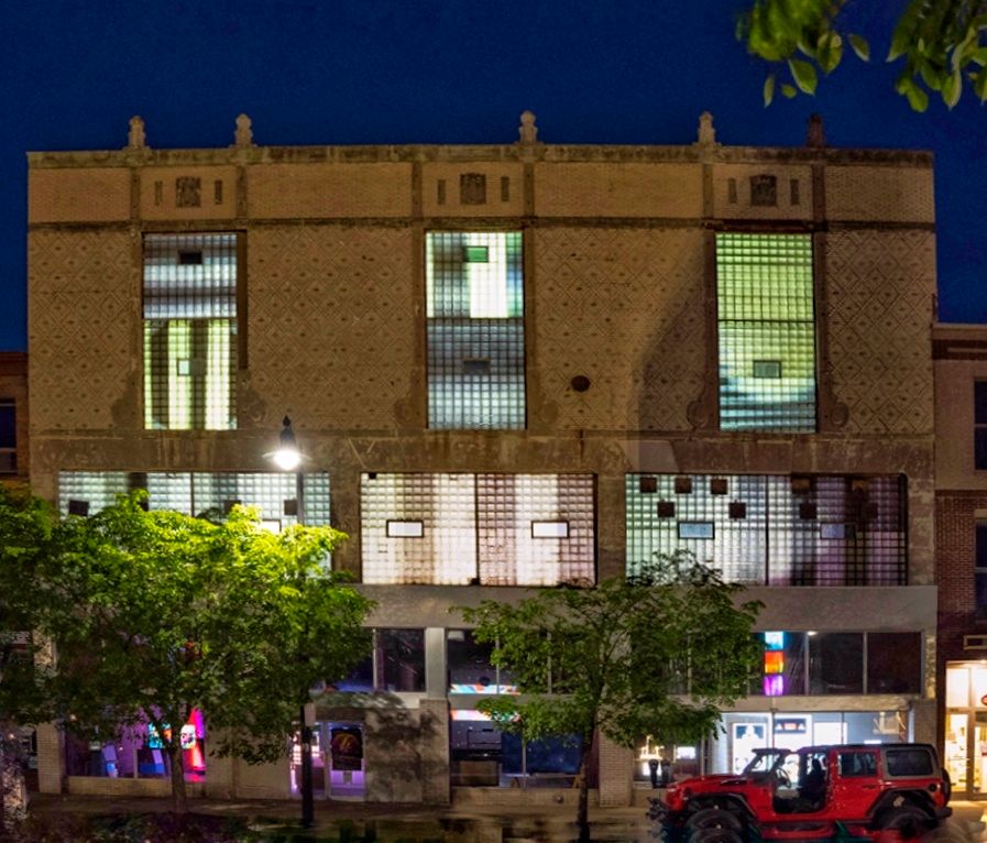 Large old facade with geometric projections lighting up glass block windows