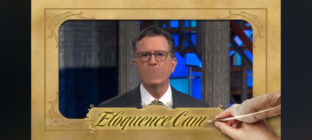 Screen shot of Stephen Colbert with blurred mouth and frame reading "Eloquence Cam"