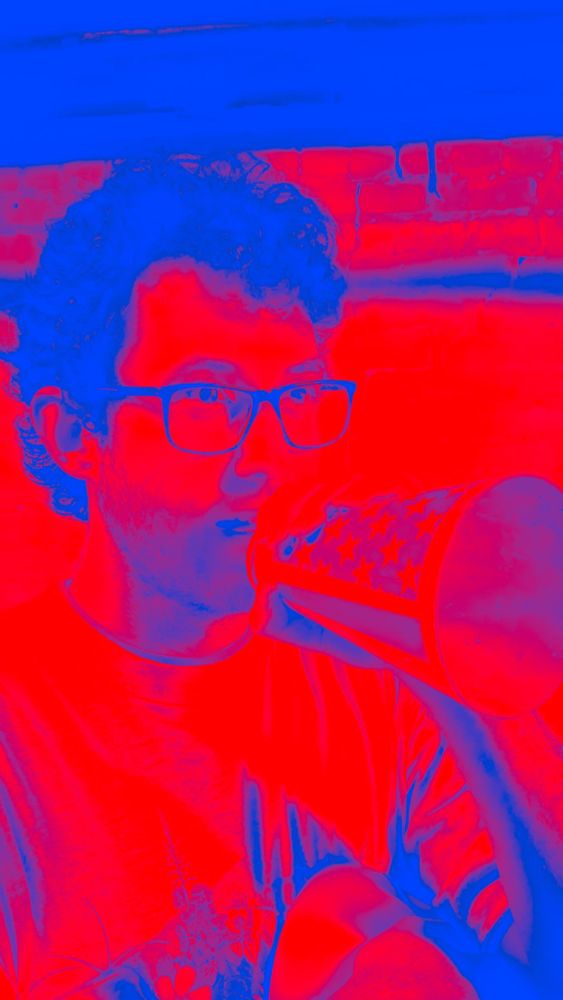 Masc with eyeglasses and stars and stripes bullhorn seen rendered in red and blue duotone palette 