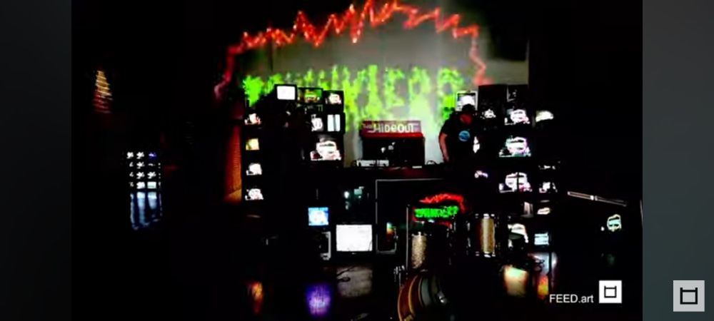 Stack of Tube TVs with a silhouette singer and projection of the scribbled word ZPHINKTERR 