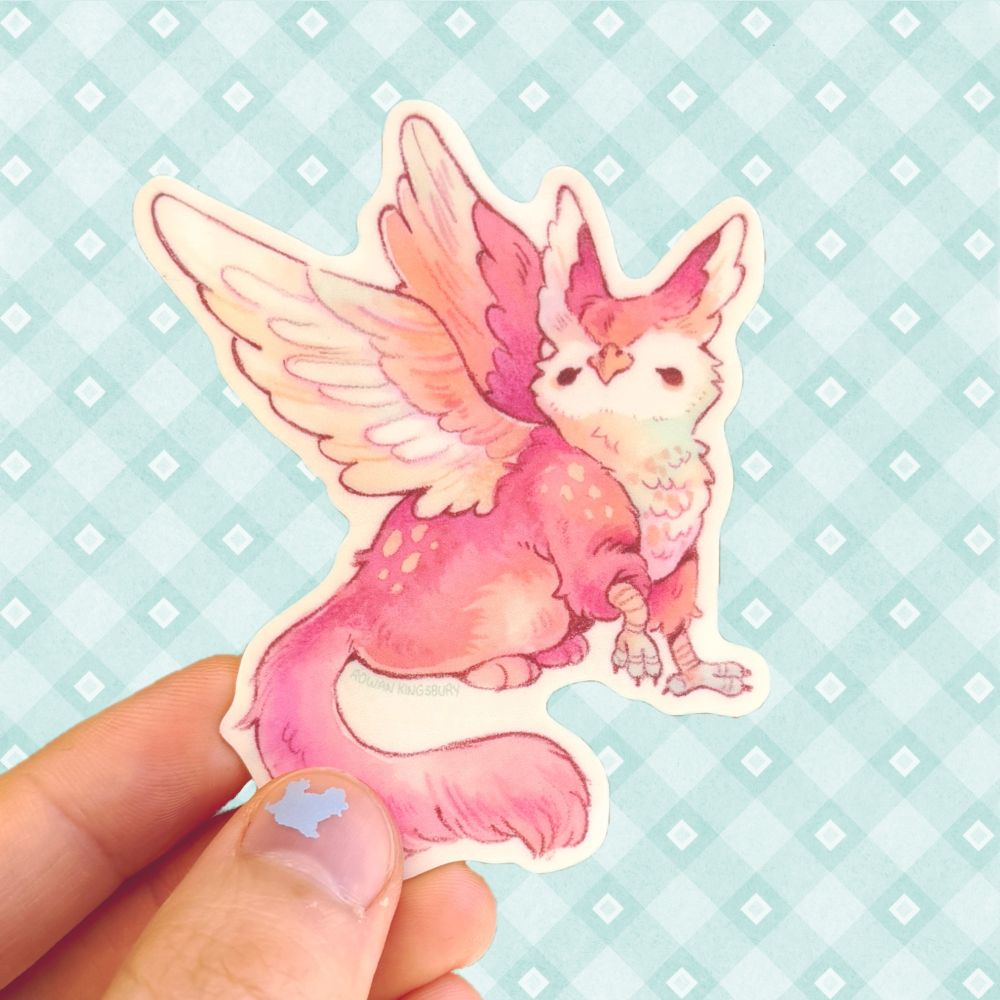 A single pastel gryphon sticker held up over a teal patterned background.