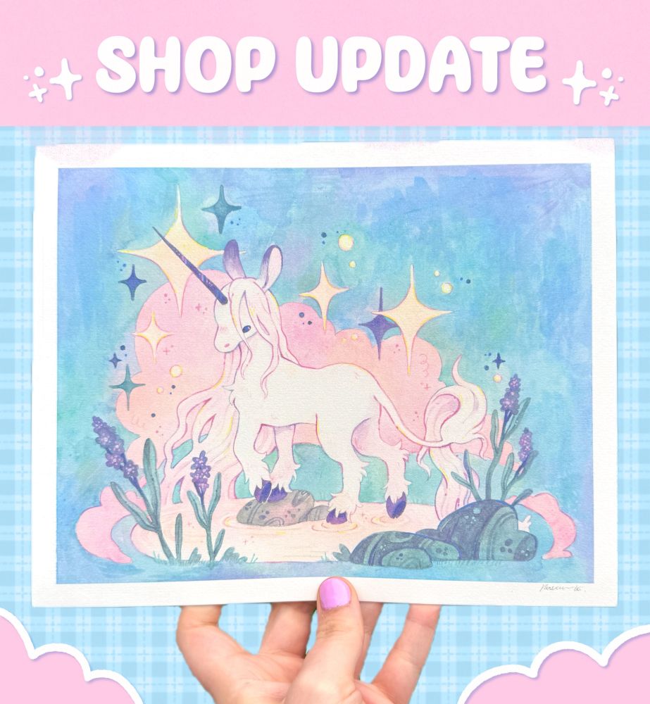 A hand holding up a print of a unicorn under “shop update!”