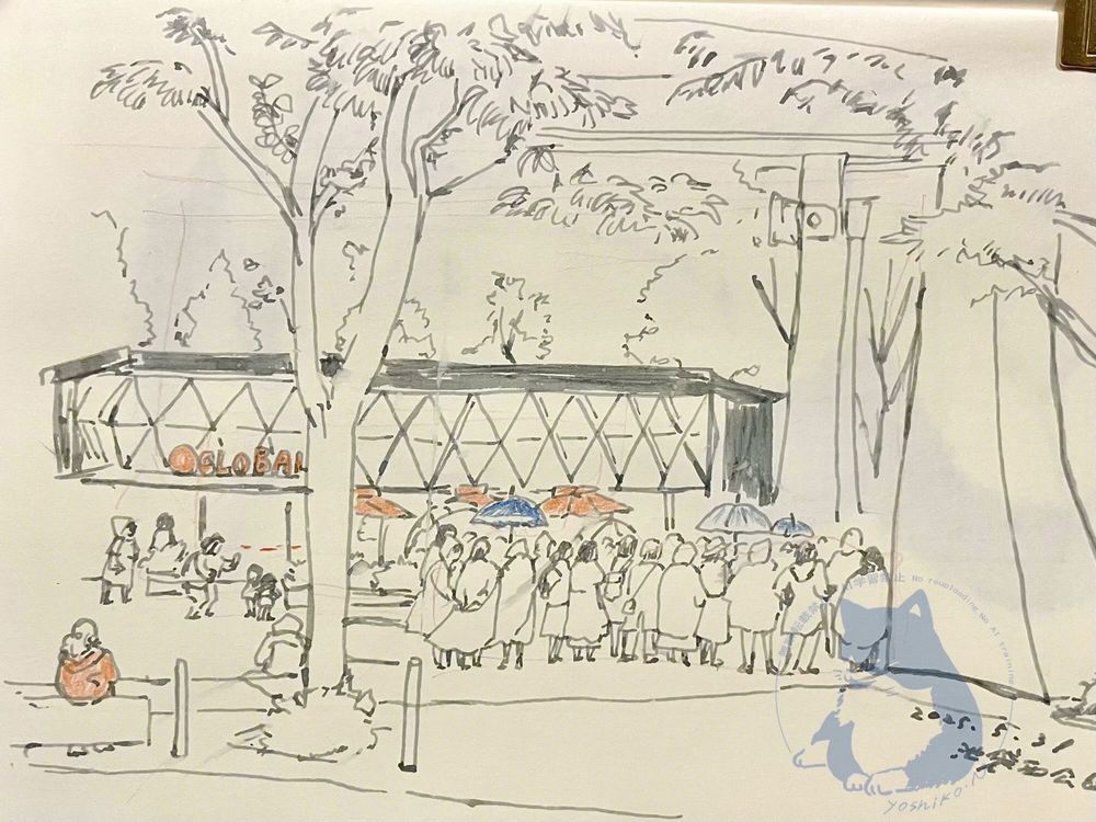 池袋駅西口公園のスケッチ。
傘をさしたりレインコートを着た人の集団が、画面中央にいる。その向こうに黒っぽいレストランの建物が見えている。