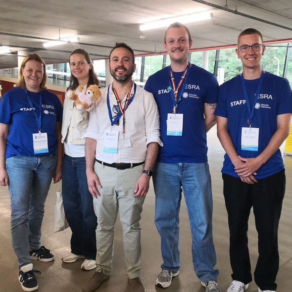 Team of people at a conference with a teddy bear